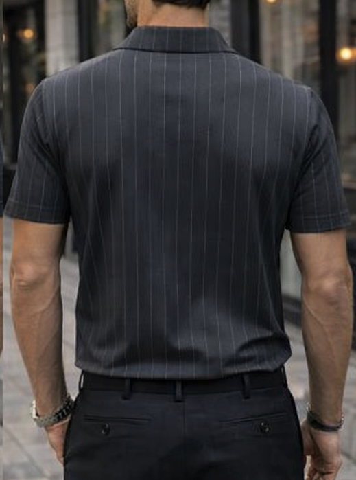 Man wearing a black pinstripe polo shirt and black pants on a city street.