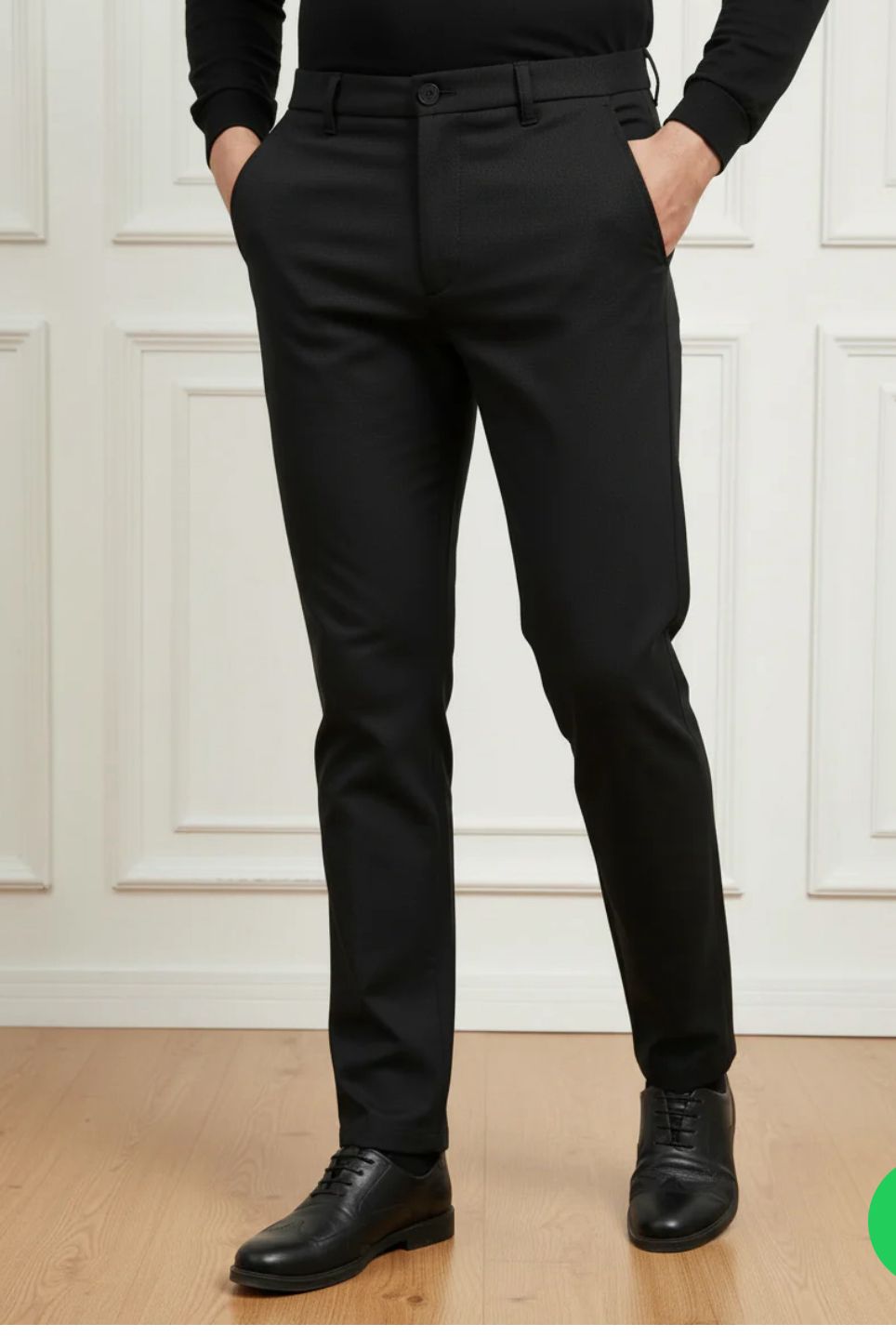Person wearing black dress pants with a white wall background