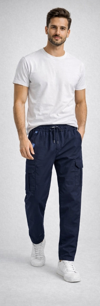 Man wearing a white t-shirt and navy cargo pants on a light gray background