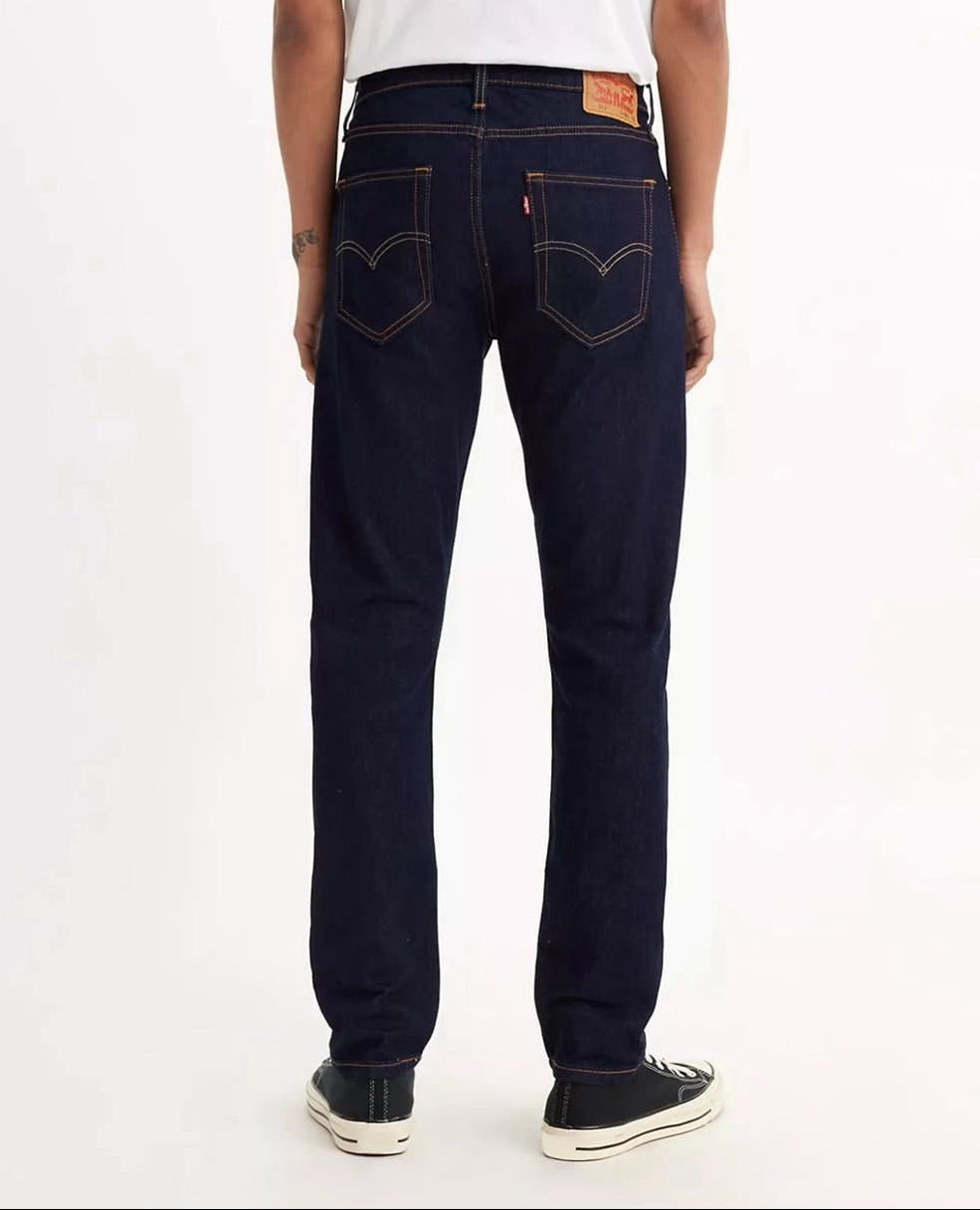 Person wearing dark blue jeans on a white background