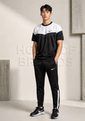 Man wearing a black and white Nike tracksuit in a minimalistic setting