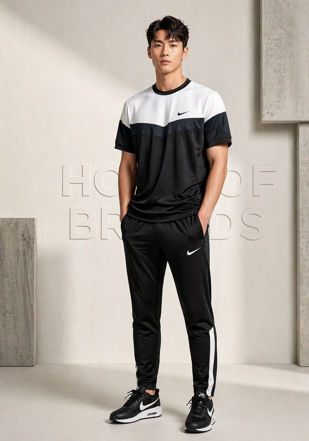 Man wearing a black and white Nike tracksuit in a minimalistic setting