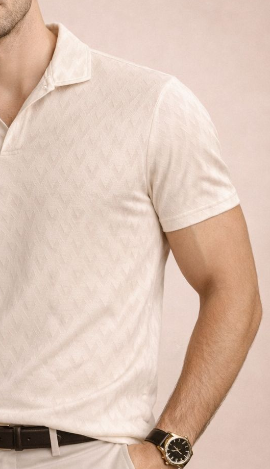 Man wearing a light-colored polo shirt and pants against a pink background