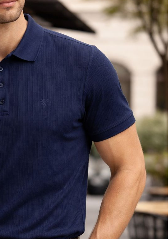 Man wearing a navy polo shirt and beige pants outdoors.